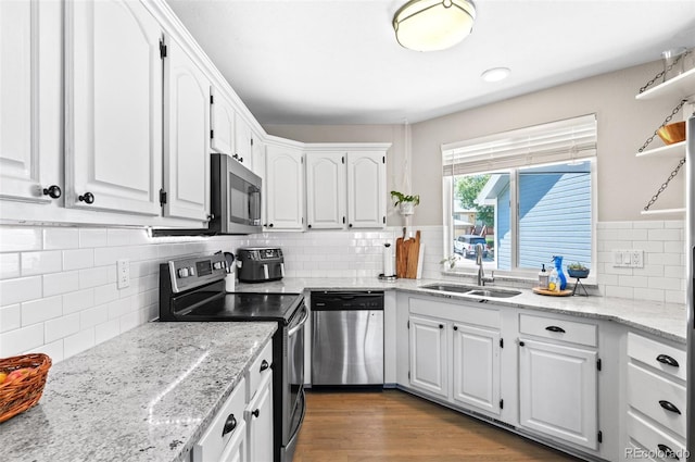 kitchen featuring stainless steel appliances, backsplash, light hardwood / wood-style flooring, and sink