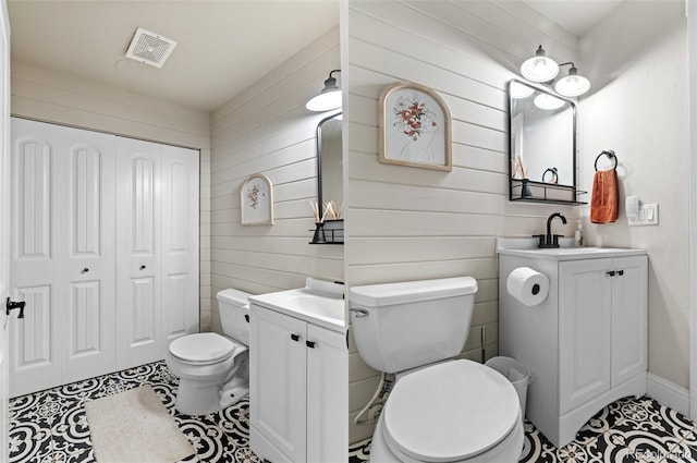 bathroom with tile patterned floors, vanity, wooden walls, and toilet