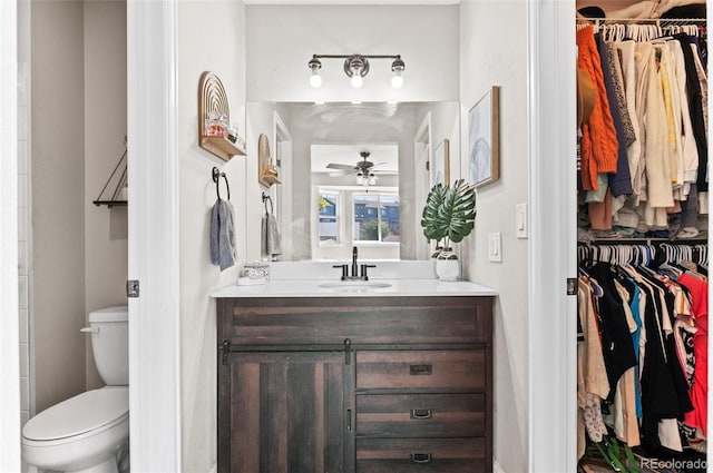 bathroom with toilet, vanity, and ceiling fan