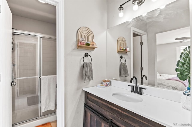 bathroom with a shower with shower door and vanity