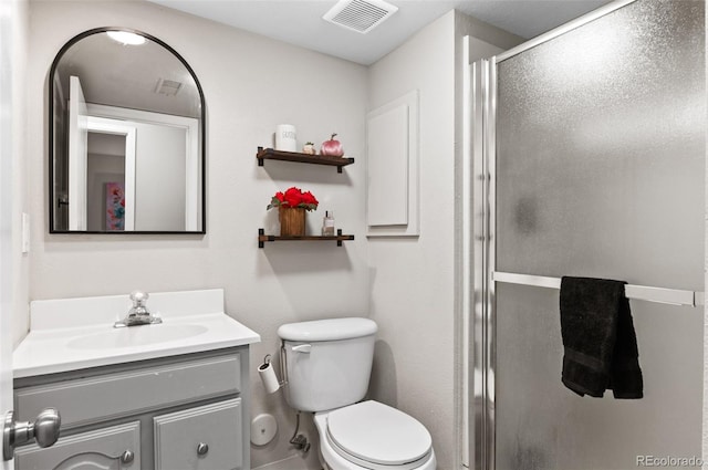 bathroom with a shower with door, toilet, and vanity