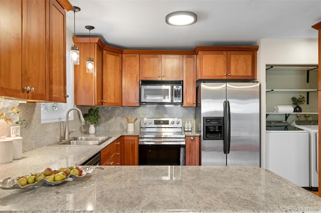 3190 Ward Ct, Wheat Ridge, CO 80215 - kitchen featuring appliances with stainless steel finishes, separate washer and dryer, a sink, and brown cabinetry