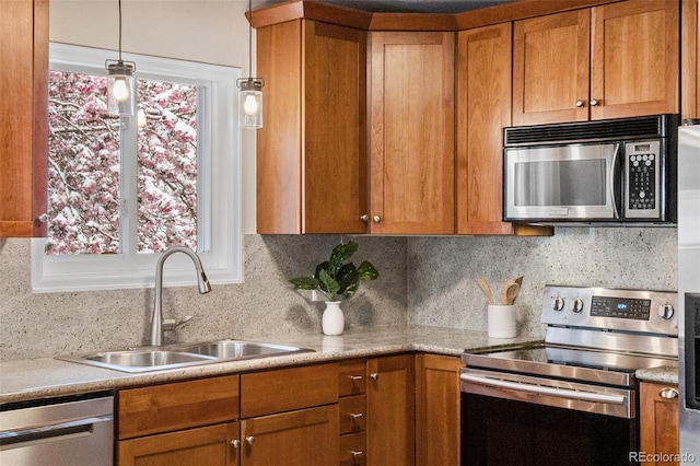 3190 Ward Ct, Wheat Ridge, CO 80215 - kitchen featuring stainless steel appliances, a sink, brown cabinetry, tasteful backsplash, and light countertops