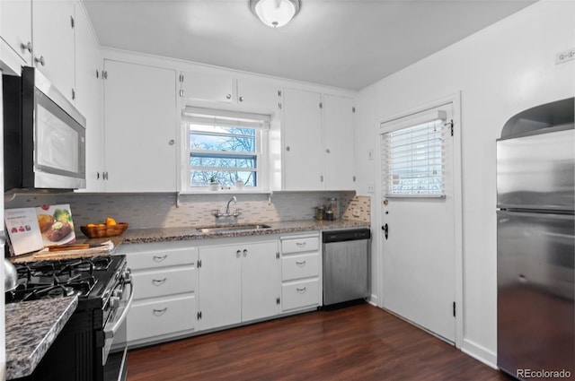 kitchen featuring stainless steel appliances, sink, white cabinets, and light stone counters