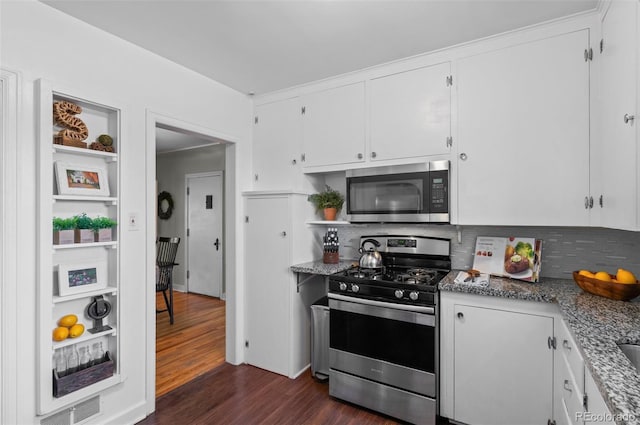 kitchen featuring appliances with stainless steel finishes, stone countertops, white cabinets, and dark hardwood / wood-style flooring