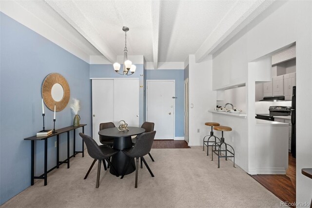 dining area featuring a textured ceiling, an inviting chandelier, and wood-type flooring