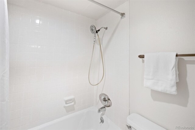 bathroom featuring shower / bath combination with curtain and toilet