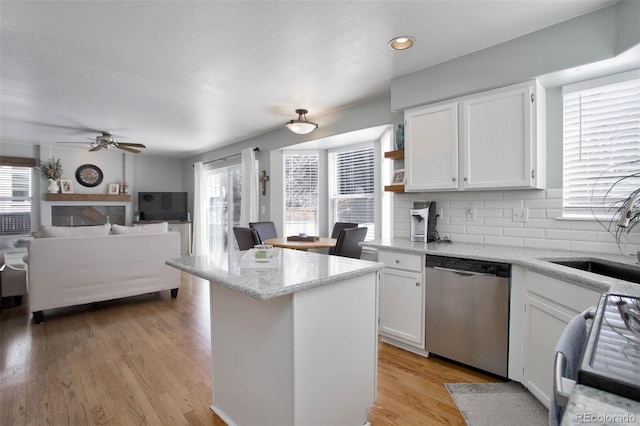 kitchen with stainless steel dishwasher, gas range oven, a sink, white cabinetry, and recessed lighting