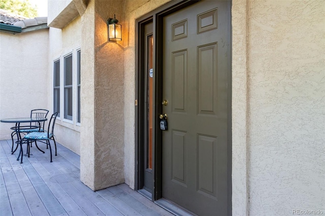 view of exterior entry with a tile roof and stucco siding