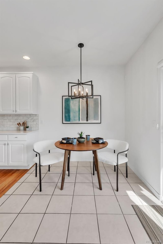 dining room with breakfast area, recessed lighting, an inviting chandelier, light tile patterned flooring, and baseboards