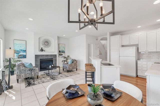 dining area with light tile patterned floors, recessed lighting, and a tile fireplace