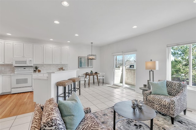 living room with light tile patterned floors, visible vents, and recessed lighting