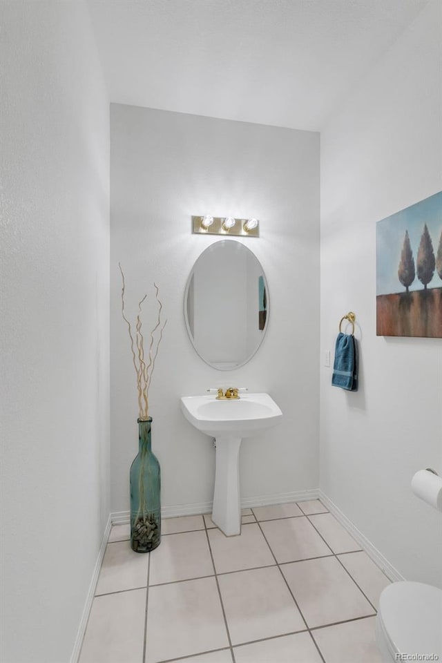 bathroom featuring tile patterned floors, baseboards, and toilet