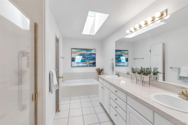 bathroom with a skylight, a stall shower, a sink, tile patterned floors, and a bath