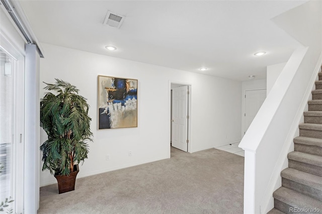 below grade area with recessed lighting, visible vents, light colored carpet, and stairs