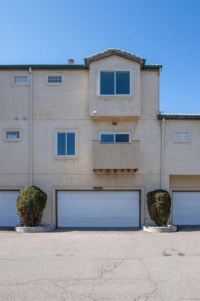 view of property with an attached garage and stucco siding