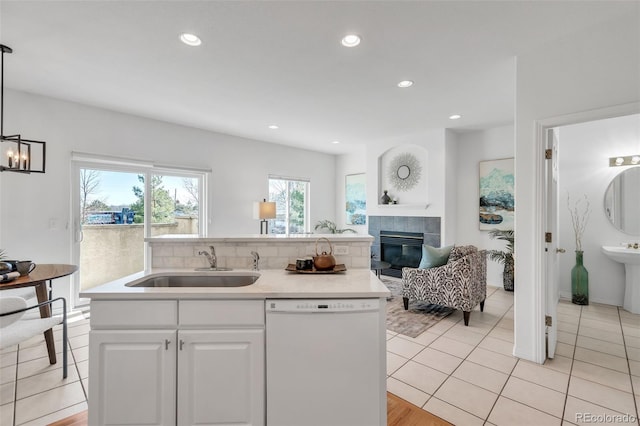 kitchen featuring an island with sink, white dishwasher, a sink, white cabinetry, and open floor plan