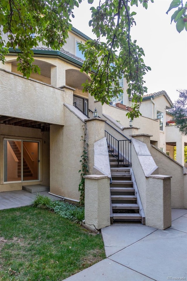 exterior space with stucco siding and stairs