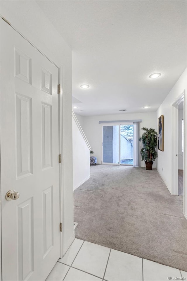 corridor featuring recessed lighting, light carpet, and baseboards