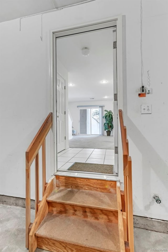 stairs featuring concrete flooring