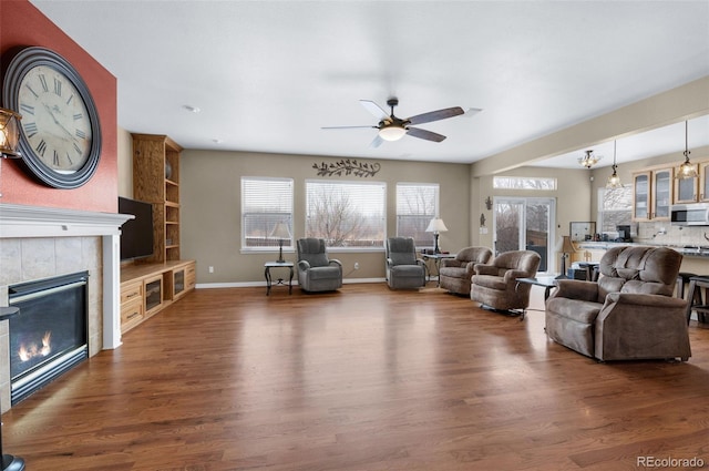 unfurnished living room with ceiling fan, a fireplace, and dark hardwood / wood-style flooring