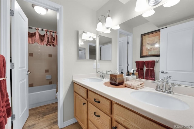 bathroom with vanity, tiled shower / bath combo, and hardwood / wood-style floors