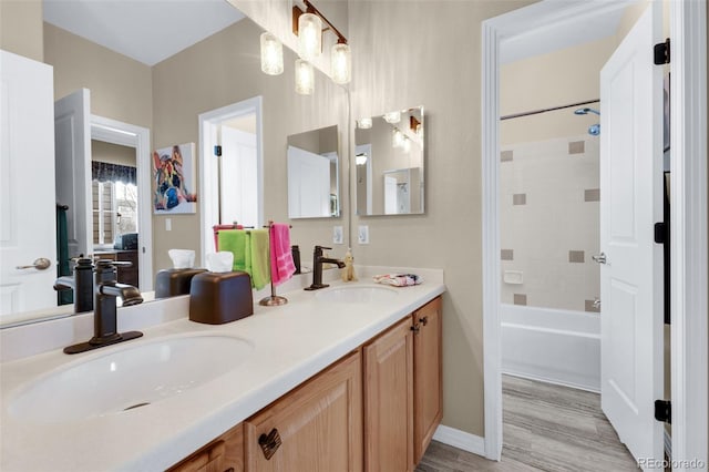 bathroom featuring hardwood / wood-style flooring, vanity, and tiled shower / bath