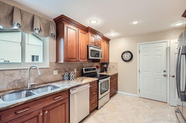 3544 Dyanna Dr, Thornton, CO 80241 - kitchen featuring stainless steel appliances, light stone countertops, decorative backsplash, brown cabinets, and light tile patterned floors