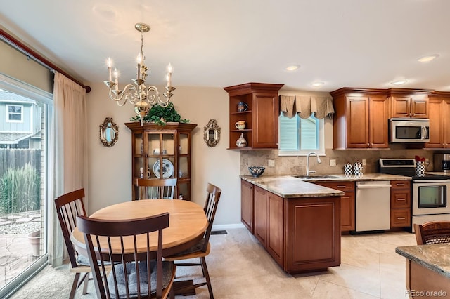 3544 Dyanna Dr, Thornton, CO 80241 - kitchen featuring stainless steel appliances, decorative backsplash, a chandelier, brown cabinetry, and open shelves