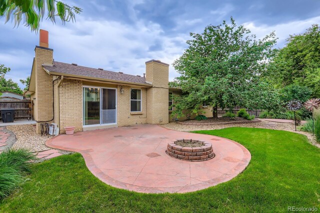 3544 Dyanna Dr, Thornton, CO 80241 - rear view of house featuring a chimney, a patio, brick siding, and a fire pit