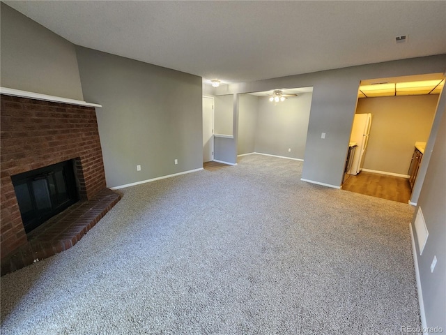 14499 E 1st Dr Unit A05, Aurora, CO 80011 - unfurnished living room featuring carpet flooring, a ceiling fan, a fireplace, and baseboards