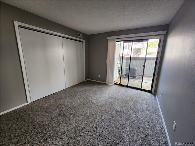 14499 E 1st Dr Unit A05, Aurora, CO 80011 - unfurnished bedroom featuring access to outside, carpet, a textured ceiling, a closet, and baseboards