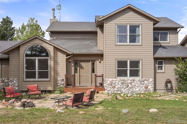 rear view of house featuring a yard and a patio