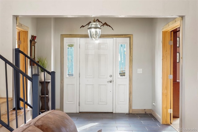 tiled entryway featuring an inviting chandelier