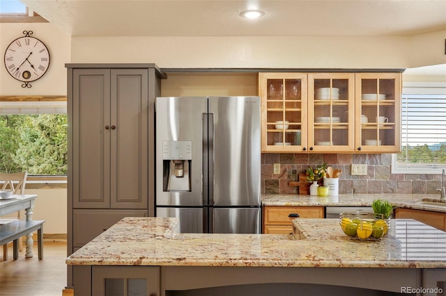 kitchen featuring plenty of natural light, stainless steel fridge with ice dispenser, hardwood / wood-style flooring, and tasteful backsplash