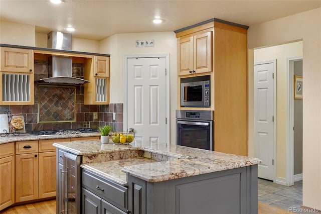 kitchen featuring backsplash, stainless steel appliances, wall chimney exhaust hood, and a kitchen island