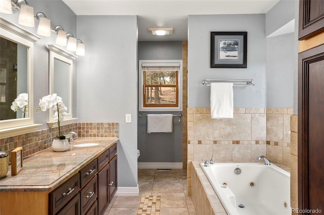 bathroom featuring tiled bath, tile patterned floors, toilet, and vanity