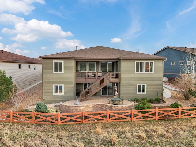 rear view of property with a wooden deck, fence private yard, and stairway