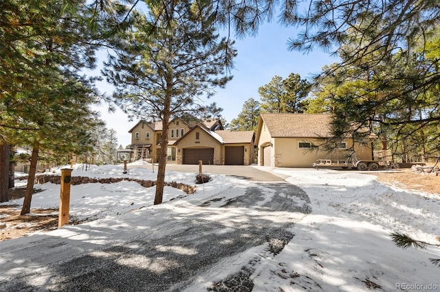 view of front of home featuring stucco siding, an attached garage, and driveway