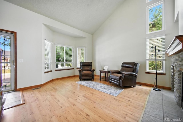 10106 Westside Cir, Littleton, CO 80125 - living area with high vaulted ceiling, light wood-type flooring, and a fireplace