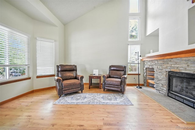 10106 Westside Cir, Littleton, CO 80125 - sitting room with healthy amount of natural light, high vaulted ceiling, wood finished floors, and a fireplace