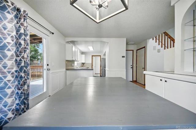 10106 Westside Cir, Littleton, CO 80125 - garage with wainscoting, freestanding refrigerator, and a decorative wall