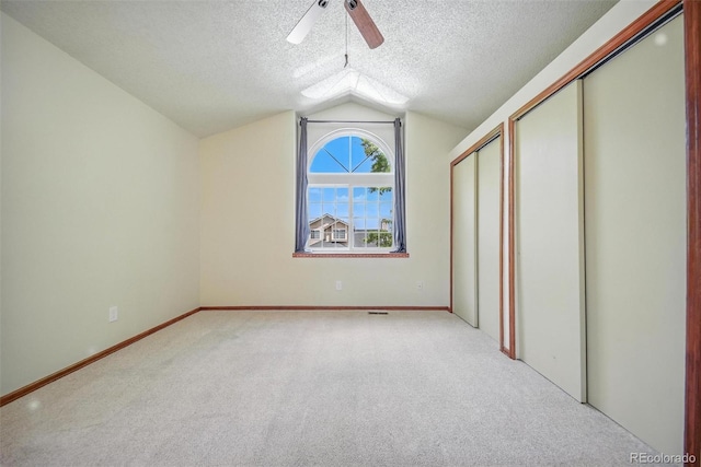 10106 Westside Cir, Littleton, CO 80125 - unfurnished bedroom featuring a textured ceiling, vaulted ceiling, light carpet, and a ceiling fan