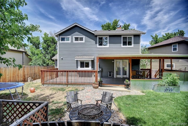 10106 Westside Cir, Littleton, CO 80125 - rear view of house featuring an outdoor fire pit, a deck, a chimney, and a trampoline