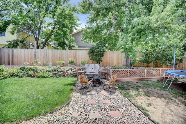 10106 Westside Cir, Littleton, CO 80125 - fenced backyard featuring a trampoline and a fire pit
