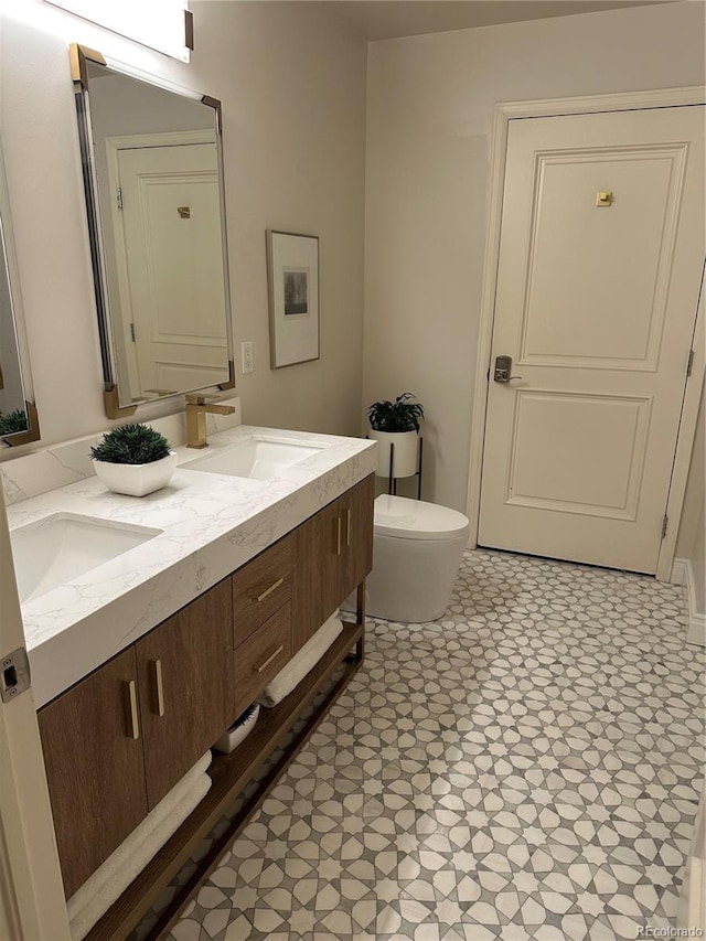 full bathroom with double vanity and toilet