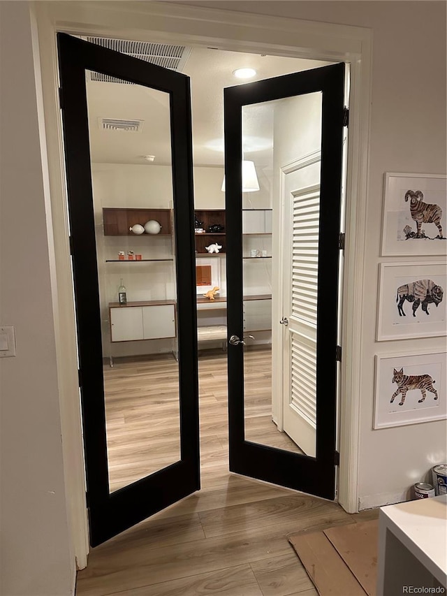 entryway featuring light wood-style floors and french doors