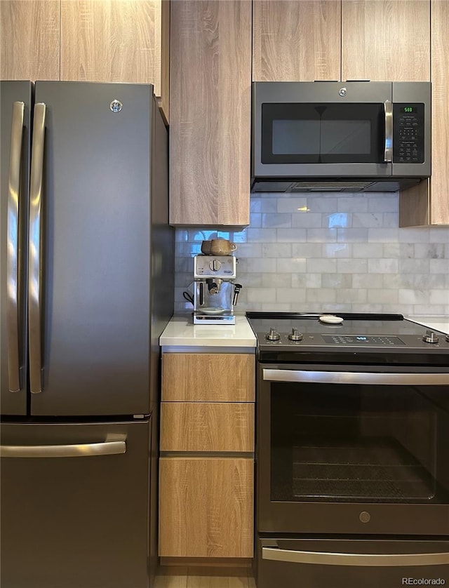 kitchen featuring appliances with stainless steel finishes, modern cabinets, backsplash, and light countertops
