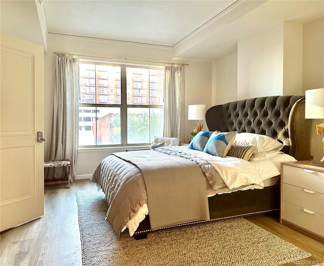bedroom with light wood-style floors and baseboards