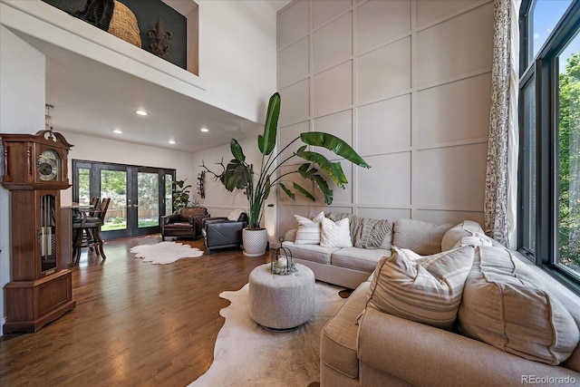 10701 Flagler Dr, Parker, CO 80134 - living room featuring wood finished floors, french doors, a towering ceiling, recessed lighting, and a decorative wall